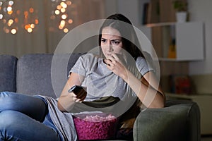 Nervous spectator watching tv at home in the night photo