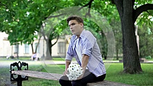 Nervous teen waiting for girlfriend with flowers bouquet, failed date, break up