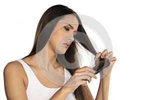 Nervous and unhappy woman brushing her long straith hair