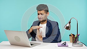 Nervous upset freelancer showing time out gesture with hands at web camera of laptop, asking more time for task completion