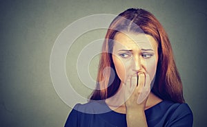 Nervous woman biting her fingernails craving something or anxious