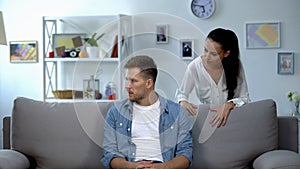 Nervous woman criticizing lazy husband sitting on sofa, family conflict, problem