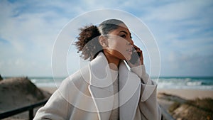 Nervous woman talking phone at ocean beach closeup. Serious african american