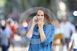 Nervous woman talking on phone on the street