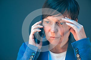 Nervous worried businesswoman during unpleasant telephone conversation