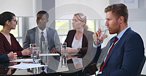 Nervous young businessman at corporate meeting feeling unwell