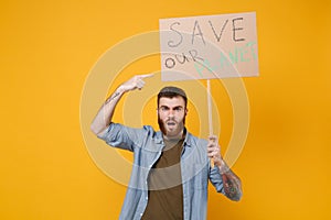 Nervous young protesting man pointing index finger on protest sign broadsheet placard on stick isolated on yellow