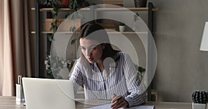 Nervous young woman feeling stressed, throwing papers in air.