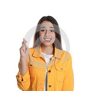 Nervous young woman holding fingers crossed on white background. Superstition for good luck