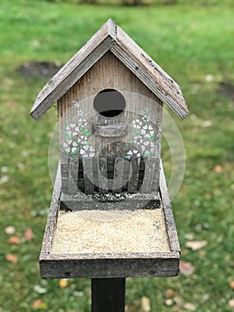 A nest box or bird house decorated with white flowers