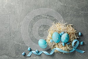 Nest with Easter eggs on grey background