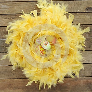 Nest made of yellow feathers with easter eggs