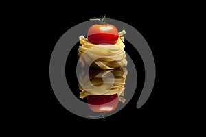 Nest pasta with red tomato black background