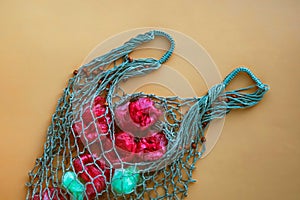 Net bag full of plastic bag fruits.