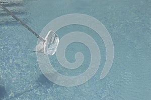 Net cleaning device in isolated pool on water with copy space around. Summer house cleaning activity