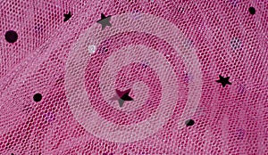 Net Fabric with embellishment of star and circle. Pink colorful netting material, abstract background.