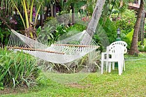 Net hammock hung on palm trees in a tropical hotel
