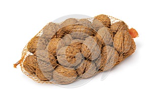 Net with whole walnuts in the shell on white background close up