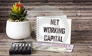 Net working capital, text on notepad with calculator and money