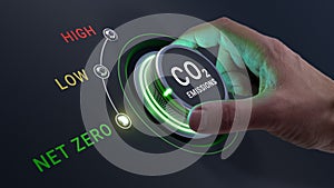 Net zero CO2 emissions and carbon neutrality target. Person's hand turning knob to lower greenhouse gas emissions