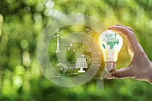 Net zero concept help reduce global warming..Hand holding natural background light bulb on green leaf with clean energy icon