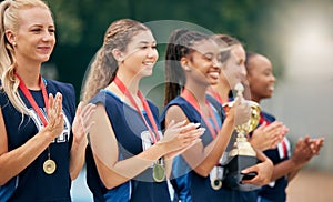 Netball team, clapping and medal, trophy and winner in sports competition, tournament and game outdoor. Teamwork