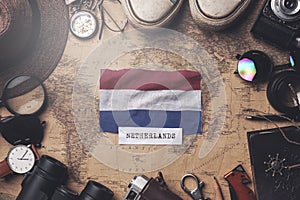 Netherlands Flag Between Traveler`s Accessories on Old Vintage Map. Overhead Shot