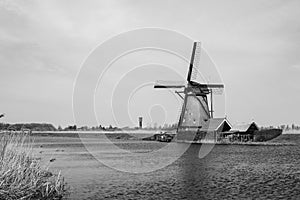 The Netherlands rural landscape with famous windmill in Kinderdijk museum in Holland. Sunny summer day in countryside.