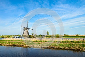 The Netherlands rural landscape with famous windmill in Kinderdijk museum in Holland. Sunny summer day in countryside