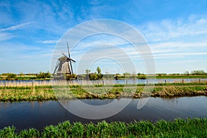 The Netherlands rural landscape with famous windmill in Kinderdijk museum in Holland. Sunny summer day in countryside