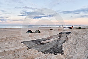 Nets and colorful fishing boats on the sand