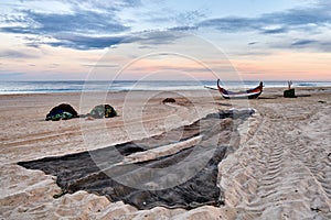 Nets and colorful fishing boats on the sand