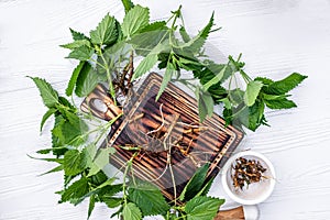 Nettle root on cutting board. Lamium album, white nettle or white dead-nettle Flowers in mortar. Preparation of elixirs