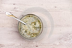 Nettle soup in bowl on wooden background