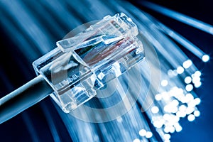 Network cable and optical fibers with lights in the ends. Blue background
