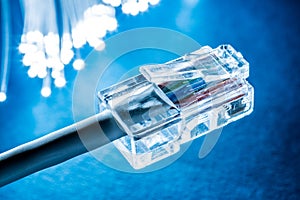 Network cable and optical fibers with lights in the ends. Blue background