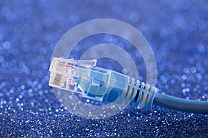 Network cable over blue sparkles background