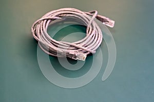 Network cable for transmitting the Internet signal is long and folded into a circle on a dark background