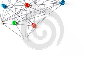 Network with colorful pins and string,  linked together with string on a white background suggesting a network of connections