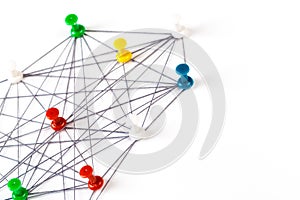 Network with colorful pins and string,  linked together with string on a white background suggesting a network of connections