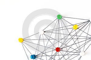 Network with colorful pins and string,  linked together with string on a white background suggesting a network of connections