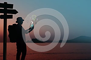 Network Connection Lost for Travel Concept, Silhouette of Backpacker using Smart Phone in unknown place with Question and photo