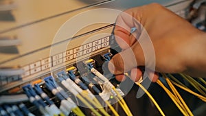 Network engineer in server room works with optical patchcord and optical module