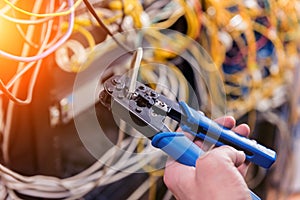 Network engineer working in server room. Connecting network cables to switches