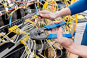 Network engineer working in server room. Connecting network cables to switches