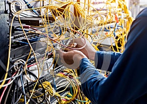 Network engineer working in server room. Connecting network cables to switches