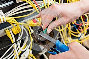 Network engineer working in server room. Connecting network cables to switches