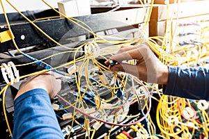 Network engineer working in server room. Connecting network cables to switches