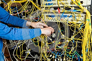 Network engineer working in server room. Connecting network cables to switches