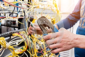 Network engineer working in server room. Connecting network cables to switches